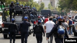 Polisi berpatroli di pasar ikan La Viga fish yang ramai pengunjung di tengah merebaknya wabah virus corona di Mexico City, Meksiko, 9 April 2020.