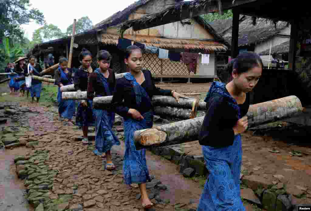 ស្រ្តីជនជាតិ Baduy ក្នុងប្រទេសឥណ្ឌូណេស៊ីសែងឈើពេលកំពុងដើរនៅខាងមុខស្ថានីយ៍បោះឆ្នោតមួយសម្រាប់ការបោះឆ្នោតជាតិនៅក្នុងភូមិ Kanekes village ក្រុង Rangkasbitung ខេត្ត Banten ប្រទេសឥណ្ឌូណេស៊ី។