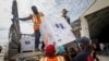 KOtak-kotak berisi bantuan vaksin COVID-19 dari program COVAX yang didukung PBB, tiba di bandara Mogadishu, Somalia, 15 Maret 2021. (AP/Farah Abdi Warsameh). Israel menyatakan ikut berpartisipasi menyumbang 1 juta dosis untuk program ini, Rabu (15/12).