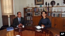 Burmese opposition leader Aung San Suu Kyi, right, and United Nations Special Rapporteur for human rights in Burma Tomas Ojea Quintana pose for the media before their meeting at her residence, in Rangoon, February 16, 2013.