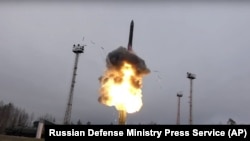 In this photo taken from undated footage distributed by Russian Defense Ministry Press Service, an intercontinental ballistic missile lifts off from a truck-mounted launcher somewhere in Russia.