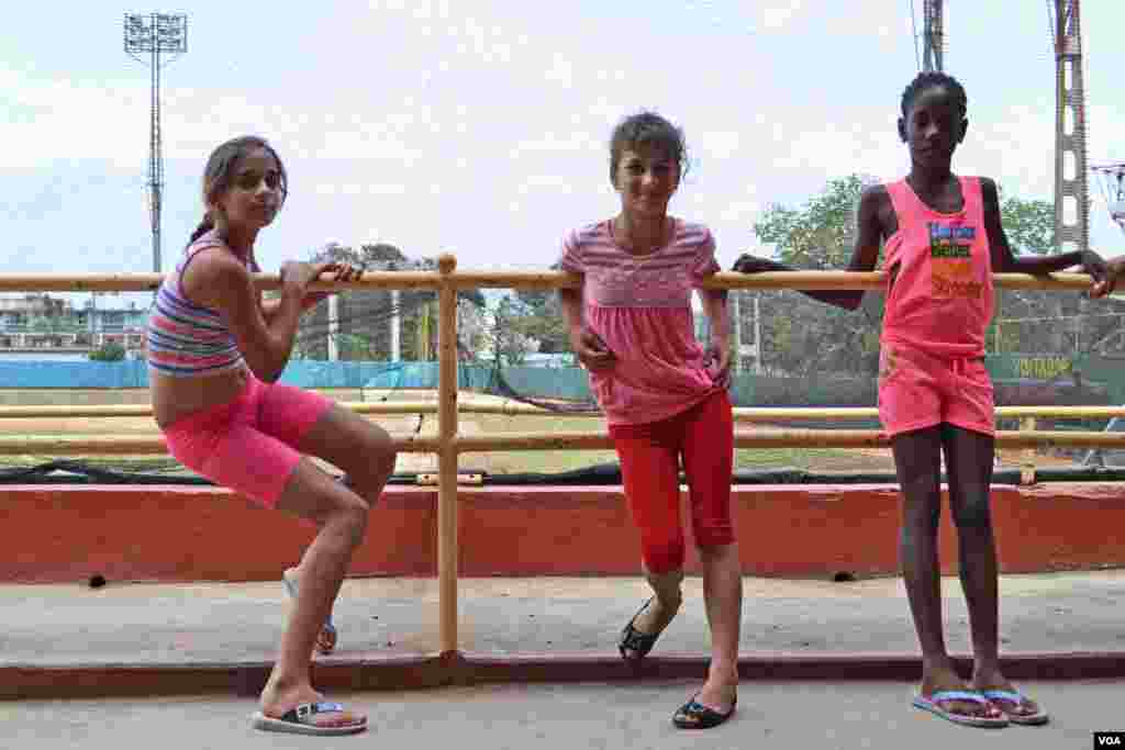 Three Cuban girls prepare for track practice outside Mayabeque baseball stadium in Havana, Cuba. (R. Taylor / VOA)