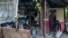 Dos jóvenes limpian una casa gravemente dañada por el terremoto en Chardonnieres, Haití el 18 de agosto de 2021.