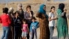 Sejumlah pengungsi asal Suriah mengantre untuk mendapatkan makanan dan bantuan lainnya di kamp pengungsi Bardarash, di sebelah utara Mosul, Irak, pada 17 Oktober 2019. (Foto: AP/Hussein Malla)