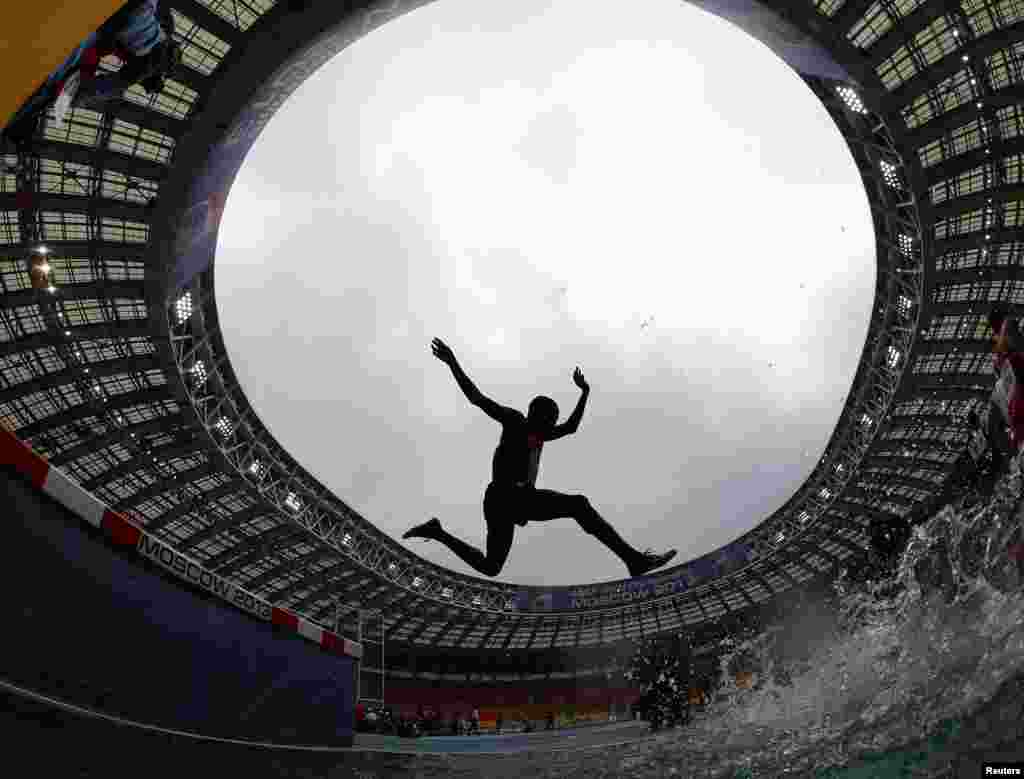 Paul Kipsiele Koech dari Kenya melompati hambatan air dalam nomor 3.000 meter putra Kejuaraan Dunia Atletik Dunia (IAAF) di Stadion Luzhniki, Moskow, Rusia.