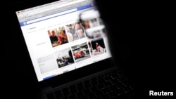 FILE - Vietnamese internet activist looks at a Facebook page at a cafe in Hanoi, Nov. 27, 2013.