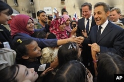 Nicolas Sarkozy (à dr.) et David Cameron saluent la foule à Benghazi (15 septembre 2011)
