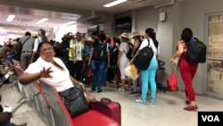 Turistas cubanos hacen cola para abordar su vuelo en el aeropuerto Toussaint Louverture en Puerto Príncipe, Haití. (S. Lemaire / VOA)
