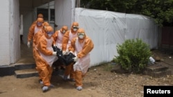 Equipo de enterramiento en un hospital de Puerto Loko, en Liberia.