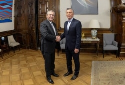 Argentina's President Mauricio Macri shakes hands with President-elect Alberto Fernandez, in Buenos Aires, Argentina, Oct. 28, 2019.