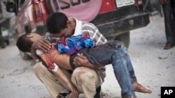 Foto bertanggal 3 Oktober 2012 ini menunjukkan seorang pria menangis sambil menggendong anak laki-lakinya yang tewas di tangan Tentara Suriah dekat rumah sakit Dar El Shifa di Aleppo, Suriah.