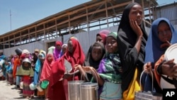 FILE - Watoto waliokimbia ukame katika eneo la kusini mwa Somalia wakiwa wanasubiri msaada wa chakula katika kituo cha kugawa chakula katika kambi moja Mogadishu, Somalia. 