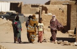 Wanawake wa Sahrawi wakitembea katika kambi ya wakimbizi ya Al Smara iliyoko jangwani huko Tindouf, kusini mwa Algeria, Machi 4, 2016.
