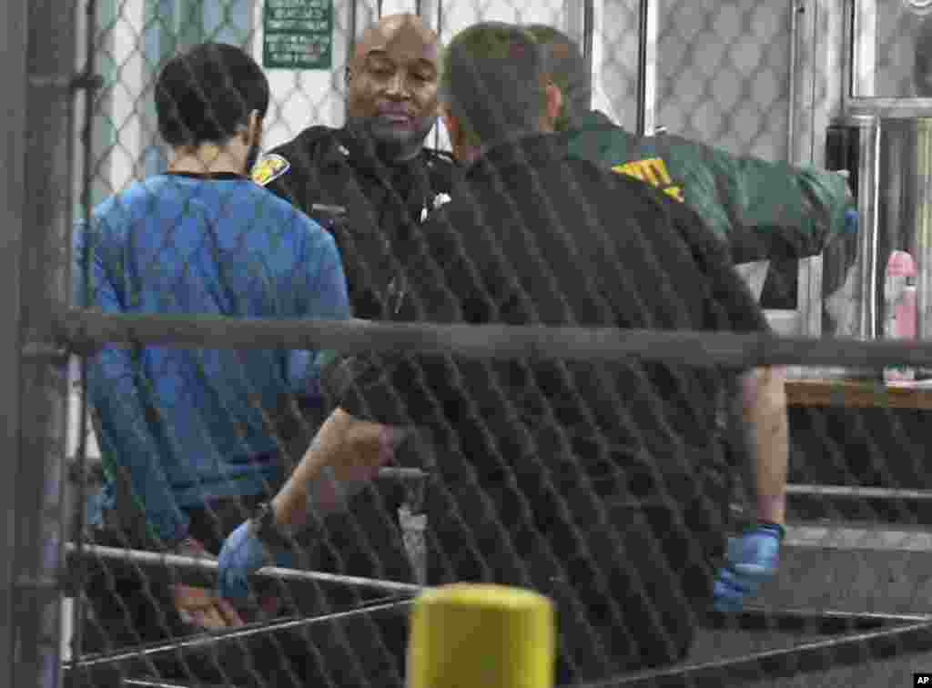 Esteban Santiago, présumé auteur de la fusillade à l'aéroport de Fort Lauderdale, tenu par des policiers, en Floride, 1er janvier 2017.