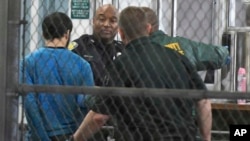 Esteban Santiago, présumé auteur de la fusillade à l'aéroport de Fort Lauderdale, tenu par des policiers, en Floride, 1er janvier 2017.