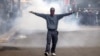 Un manifestant réagissant aux tirs de gaz lacrymogène de la police lors d'une manifestation contre les nouvelles taxes devant le parlement le 20 juin 2024 