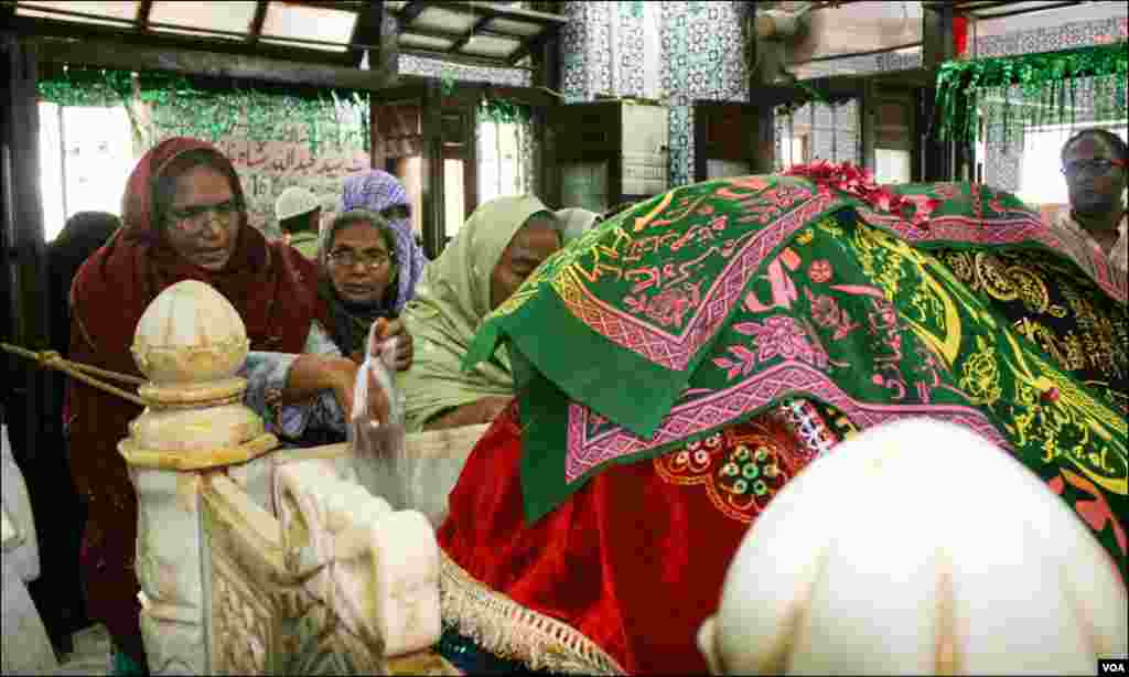 عبداللہ شاہ غازی کی قبر پر موجود عقیدت مند۔ قبر اونچائی پر واقع ہے جو 1948ءتک پہاڑی ٹیلا تھا