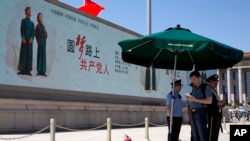在北京天安门广场一个巨大的电子显示屏上的宣传口号：圆梦路上的共产党人。（2014年5月28日）