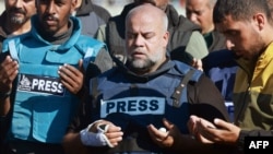 Kepala Biro Al Jazeera di Gaza, Wael Al-Dahdouh (tengah) berdoa dalam prosesi pemakaman putranya Hamza Wael Dahdouh yang tewas dalam serangan udara Israel di Rafah, Jalur Gaza, pada 7 Januari 2024. (Foto: AFP)