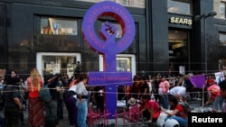  Activists and relatives place pink crosses at a makeshift monument against femicide with names of the states of Mexico, during a protest against femicide and violence against women, in Mexico City, March 24, 2019. The sign reads: "No more femicides."