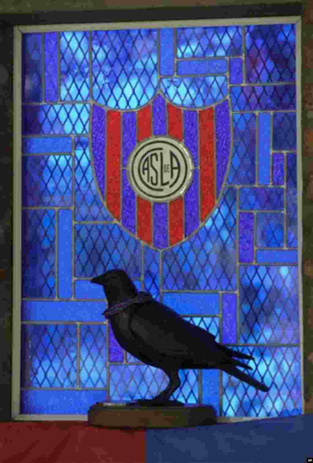 A statue of a crow is silhouetted against the San Lorenzo de Almagro chapel window in Buenos Aires, Argentina, Thursday, March 14, 2013. The San Lorenzo soccer team is sometimes called the "Crows," after the black color of a priest's robe.