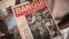 Un vendeur de souvenirs présente le premier numéro de l'hebdomadaire "Bangui Match" portant la photo de Bokassa, à Bangui, le 17 septembre 2019.