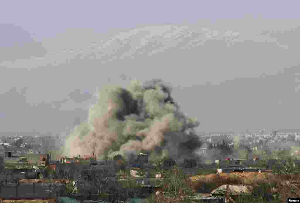 Smoke rises after what activists describe as barrel bombs are dropped by government forces in Daraya, near Damascus, Jan. 31, 2014.