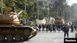 Army tanks and riot police are seen outside the presidential palace in Cairo, December 12, 2012. 