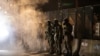 Un grupo de agentes custodia la corte federal de Justicia en Portland después de disparar gases lacrimógenos a los manifestantes el 29 de julio de 2020, al amanecer.