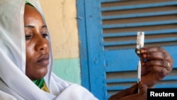 Une femme prépare un vaccin au Darfour, le 8 octobre 2012.