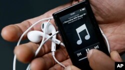 FILE- A man holds a digital music player in London, Feb. 26, 2013. 
