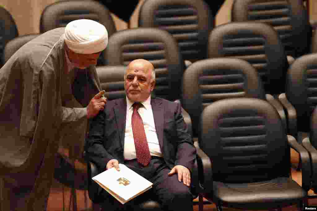 Shiite Sheikh Humam Hamoudi (left), Iraq's new deputy speaker of the Iraqi Council of Representatives, speaks with Iraq's incoming Prime Minister Haider al-Abadi as they attend a parliamentary session to vote on Iraq's new government at the parliament headquarters, Baghdad, Sept. 8, 2014.