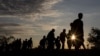 Migrants walk along rail tracks as they arrive at a collection point in the village of Roszke, Hungary, Sept. 8, 2015, after crossing the border from Serbia.