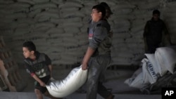 Warga Palestina menerima bantuan makanan dari UNRWA di gudang PBB di kamp pengungsi Shati di Kota Gaza, 14 Januari 2018.