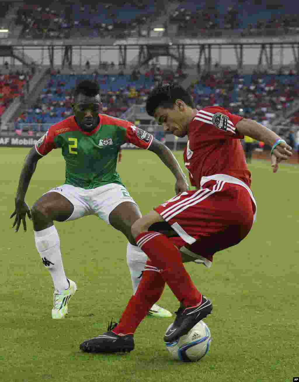 Ivan Edu Salvador de la Guinée équatoriale, à droite, aux prises avec Burkina Faso Steeve Yago, à gauche, au cours de la rencontre Guinée équatoriale-Burkina Faso lors de la Coupe d'Afrique des Nations Groupe A match à Bata, en Guinée équatoriale, mercredi 21 janvier 2015.
