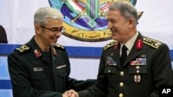 Kepala angkatan bersenjata Turki, Jenderal Hulusi Akar (kanan) diterima Panglima militer Iran Jenderal Mohammad Hossein Bagheri, di Teheran, Senin (2/10). 