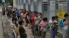 People line up at a polling center to vote in an unofficial referendum on democratic reform in Hong Kong, June 22, 2014. 