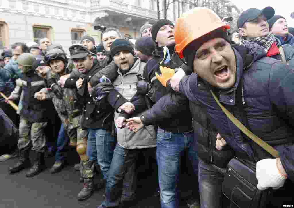 Anti-government protesters stand in a line outside the Ukrainian Parliament building in Kyiv.