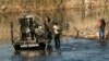 Una familia migrante es recogida por un miembro del Departamento de Seguridad Pública de Texas después de quedar varada en la orilla del río durante horas, en Eagle Pass, Texas, el 18 de enero de 2024.