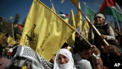 Les Palestiniens brandissent le drapeau national et celui du mouvement Fatah lors d'un rassemblement marquant le 13ème anniversaire de la mort du fondateur du Fatah et dirigeant de l'Autorité palestinienne Yasser Arafat, dans la ville de Gaza,11 novembre 2017.