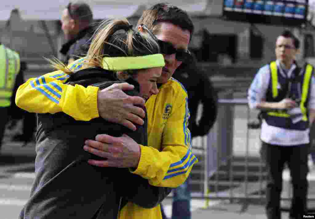 A woman is comforted by a man near a triage tent set up after explosions went off at the 117th Boston Marathon, April 15, 2013.
