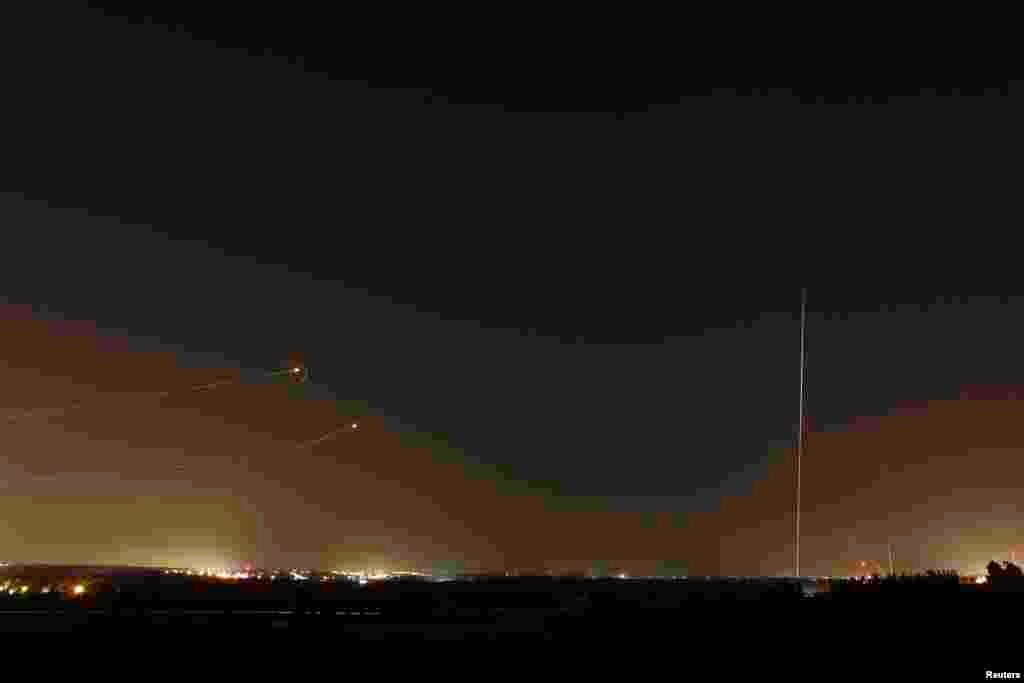 Rockets launched from the Gaza Strip towards Israel (at right) as a rocket by the Iron Dome anti-missile system (at left) is fired to intercept them, before a five-day ceasefire was due to expire, Aug. 19, 2014.