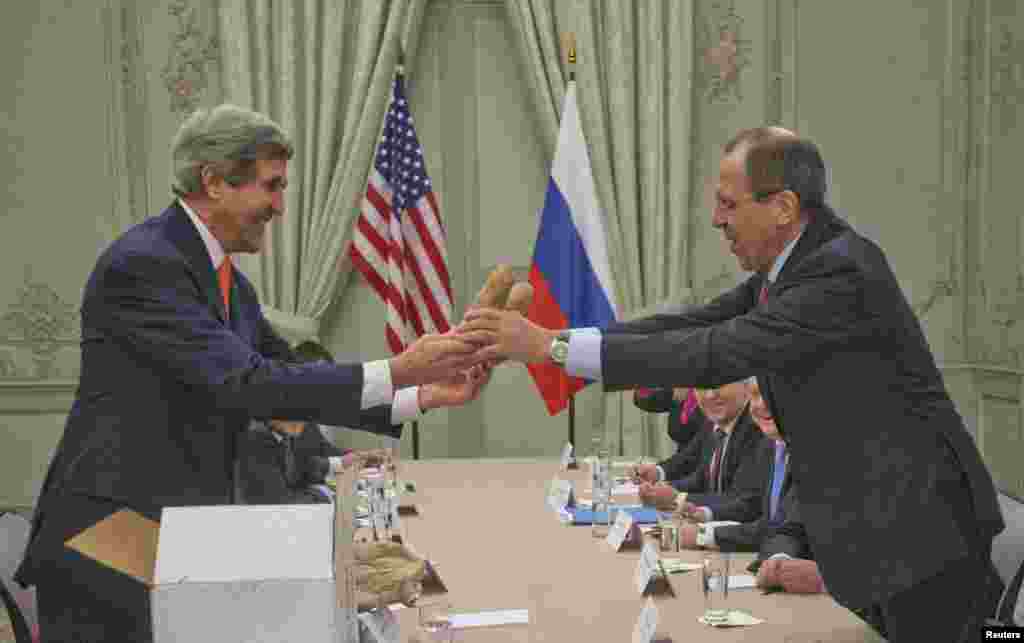 U.S. Secretary of State John Kerry (L) gives a pair of Idaho potatoes as a gift to Russia's Foreign Minister Sergei Lavrov at the start of their meeting at the U.S. Ambassador's residence in Paris, France.