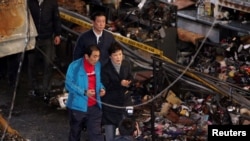 韩国总统朴槿惠12月1日视察一个市场发生火灾后的现场。