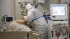 Un miembro del personal médico que usa un traje especial para protegerse contra el COVID-19 trata a un paciente con coronavirus en una UCI en el Hospital Clínico Regional 1, en Krasnodar, sur de Rusia, el 2 de noviembre de 2021.