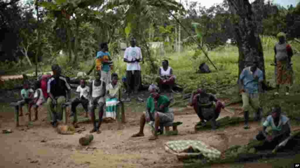 Les habitants du village de Freeman Réserve, à environ 30 miles au nord de Monrovia, au Libéria, contemplent des membres du service d'ambulance du district 13 ramasser six malades suspects d'Ebola mis en quarantaine mardi 30 septembre 2014.