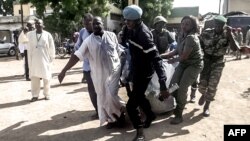 Des forces de sécurité transportent, dans une couverture, des restes des victimes d'une double explosion dans la ville camerounaise de Maroua, dans le nord, 22 juillet 2015.