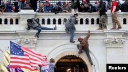 FILE - Supporters of U.S. President Donald Trump fight with members of law enforcement at a door they broke open as they storm the U.S. Capitol Building in Washington, Jan. 6, 2021.