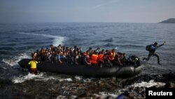 Arrivée d'un grand nombre de migrants à bord d'une très petite embarcation sur une plage de l'île grecque de Lesbos, le 19 octobre 2015.