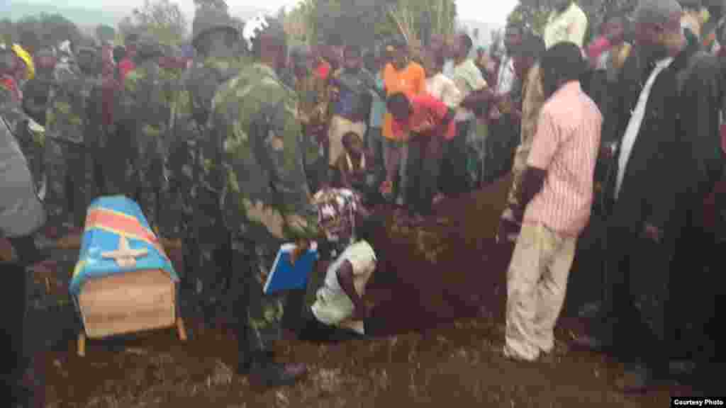 Un homme essaie de creuser un trou pour mettre le cercueil d'une victime, en RDC, Kamanyola dans le Sud-Kivu, 16 septembre 2017. 